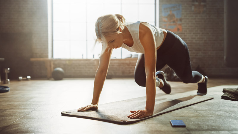 Beautiful and Young Girl Doing Running Plank Exercise on Her Fitness Mat