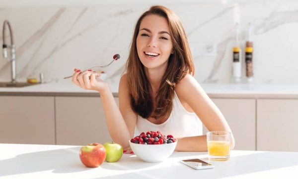 Young woman eating fresh berries.
